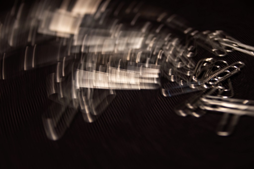 Camera spin image of silver paperclips on a black background