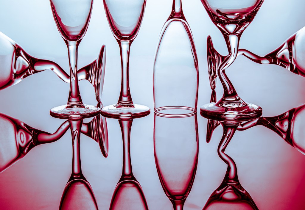 art photography, burgundy and blue grey  light behind wine and martini glasses, abstract art