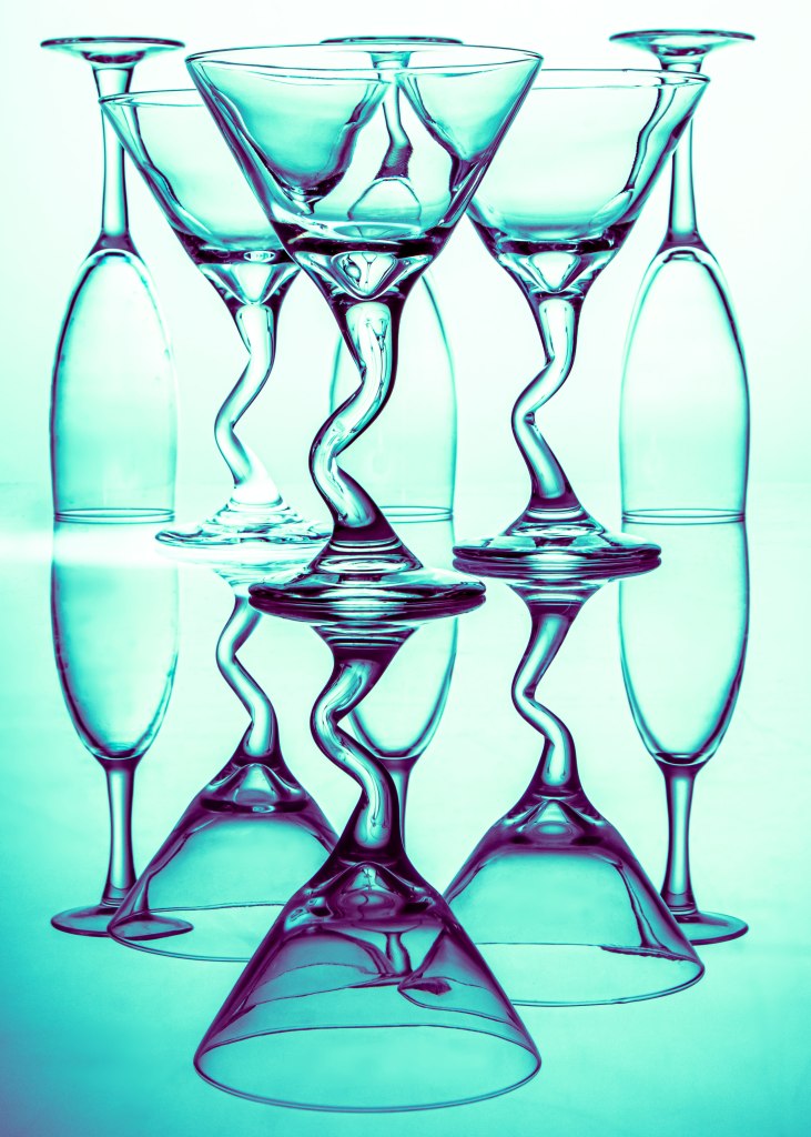 art photography, teal light behind wine and martini glasses, abstract art