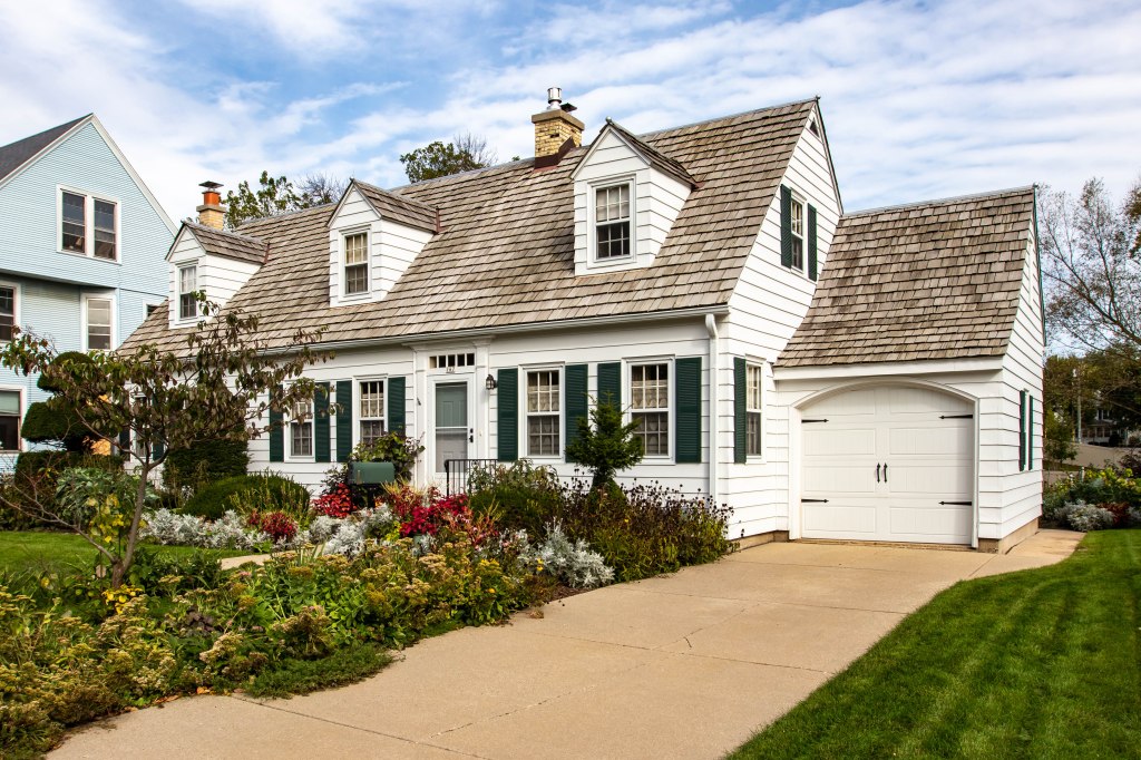 White colonial Tudor house with gorgeous garden
